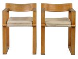 two wooden chairs with beige cushions on them against a white background