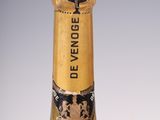 an old bottle of champagne with a gold label on a white background