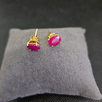 une paire de boucles d'oreilles roses posées sur un oreiller
