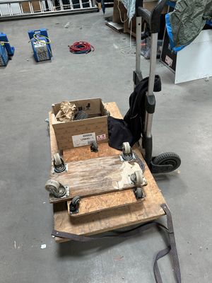 un petit chariot sur lequel sont posées deux caisses, dans un entrepôt