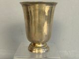 a silver vase sitting on top of a glass stand