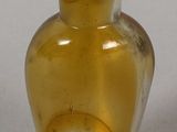 a yellow glass vase with a green lid