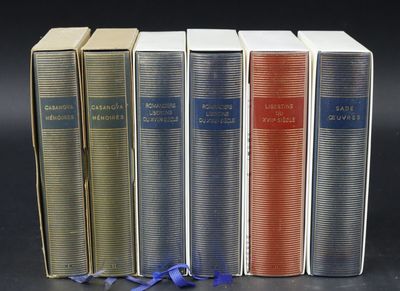 four books are lined up in a row on a black surface