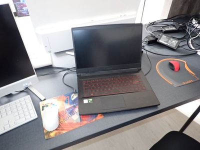 un ordinateur portable posé sur un bureau, à côté d'un écran d'ordinateur