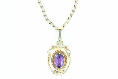 une photo d'un collier avec une pierre violette suspendue à une chaîne