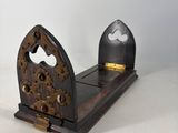 a small clock that is on a stand on a table