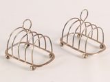 two pairs of silver plated birdcages on a white surface