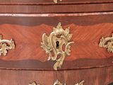 a wooden chest of drawers with gold decorations on it