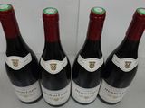 four bottles of wine are lined up in a row on a table