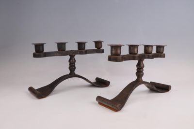 paire de bougeoirs anciens en fonte, posés sur des socles en fonte