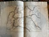 an old book with a map on it sitting on a table