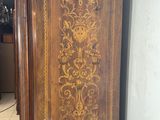 a tall wooden cabinet with a floral design on it