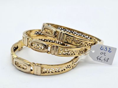 two gold bracelets with a price tag on a white background