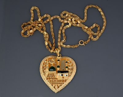gold plated necklace with a heart shaped pendant with a house in the middle