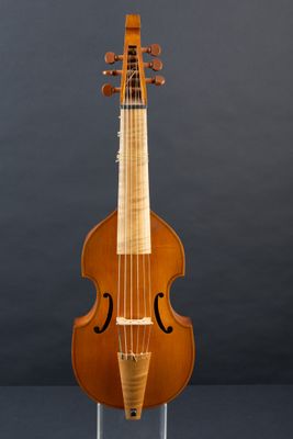 an old violin on a stand against a gray background