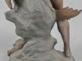 statue of a man holding a bird on a rock