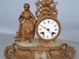 une horloge en or posée sur un socle en marbre