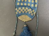 a blue and yellow hat with tassels hanging from it