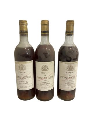 trois bouteilles de vin posées les unes à côté des autres sur une surface blanche