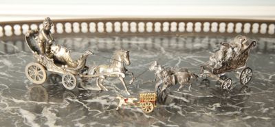 a silver tray with silver figurines of horses pulling a carriage