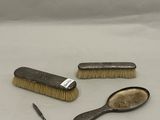 trois brosses et un peigne posés sur une surface blanche