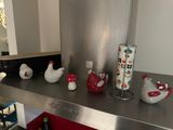 a bunch of chicken figurines on a shelf in the kitchen