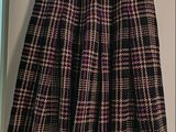 a black and pink plaid skirt hanging on a hanger