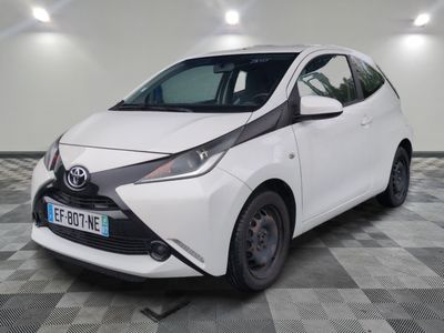 the white toyota ay is parked in a room with a checkered floor