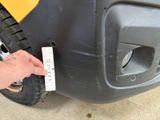 a person that is holding a remote control in front of a car
