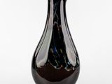un vase noir posé sur une surface blanche