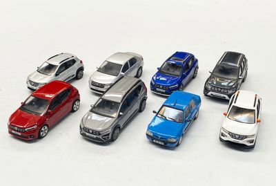 plusieurs petites voitures sont alignées sur une surface blanche