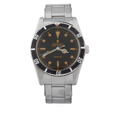 une montre au cadran noir montée sur un bracelet en acier