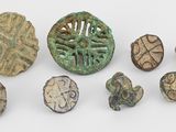Plusieurs objets anciens sont exposés sur une surface blanche