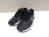 Les chaussures de course Nike noires et blanches sont posées sur une surface blanche
