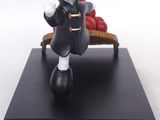a figurine of a man with a hat on a bench