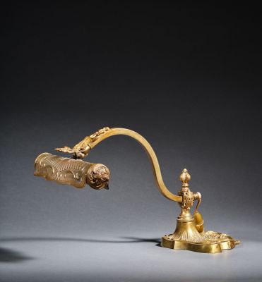 a gold plated desk lamp with a brass shade and a brass handle