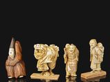 an assortment of carved figurines of people on a black surface