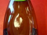 une bouteille d'Aperi Chop posée sur un support rouge