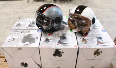 Des cartons contenant des casques sont empilés les uns sur les autres sur une palette