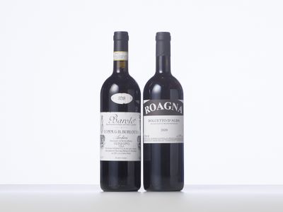 two bottles of red wine sitting next to each other on a table
