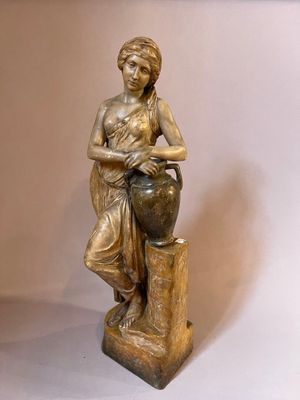 statue of a woman sitting on a tree stump holding a vase