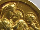 une image représentant une médaille d'or sur laquelle figure une femme tenant un bébé dans ses bras