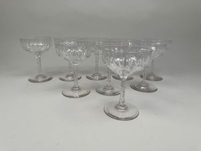 six verres à pied sont alignés sur une surface blanche