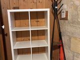 une bibliothèque blanche avec un porte-manteau à côté