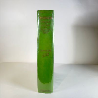 a green book sitting on a table with a white background