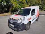une camionnette blanche avec une bande orange garée sur un parking