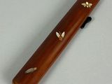 a small wooden pipe with bees on it on a table