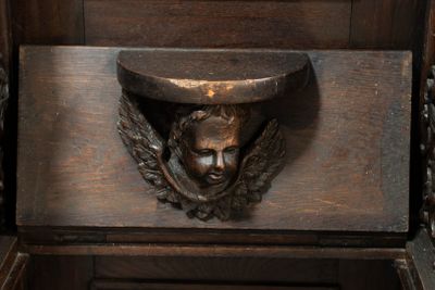 a wooden cabinet with a carving of a man ' s head on it
