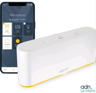 un appareil connecté blanc et jaune à côté d'un iPhone