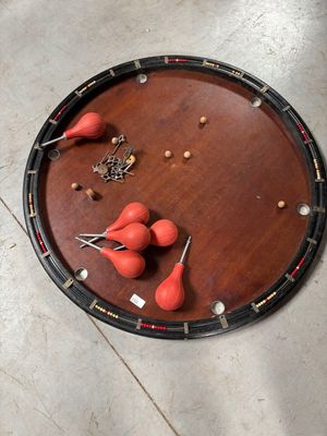 un plateau en bois posé par terre, sur lequel se trouvent des boules rouges